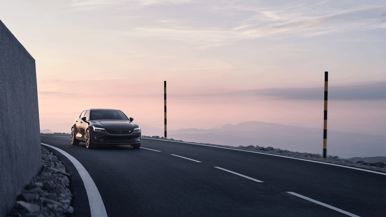 Polestar 2 Long range Dual motor in Space with Performance Pack driving in the sunset.