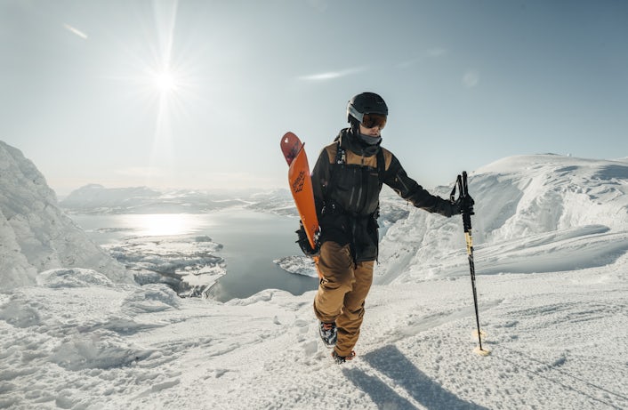 Skier walking uphill with the sun in the back