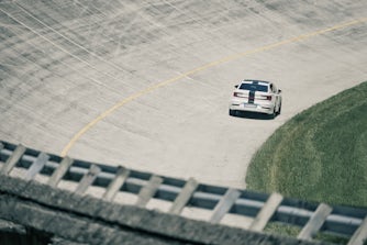 white Polestar 2 with black stripe across the car driving on the Monza race track