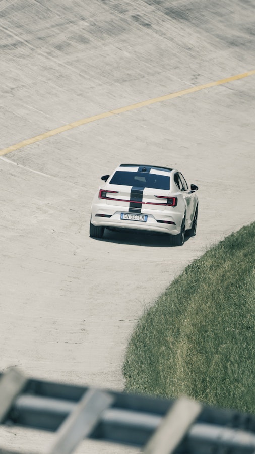 white Polestar 2 with black stripe across the car driving on the Monza race track