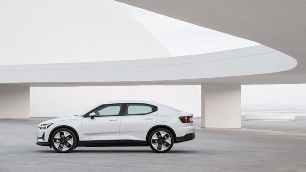 A white Polestar 2 standing next to a bridge.