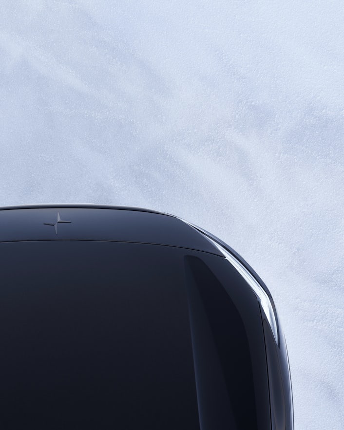 Brid's-eye view captures the front of a black Polestar car parked on snow.
