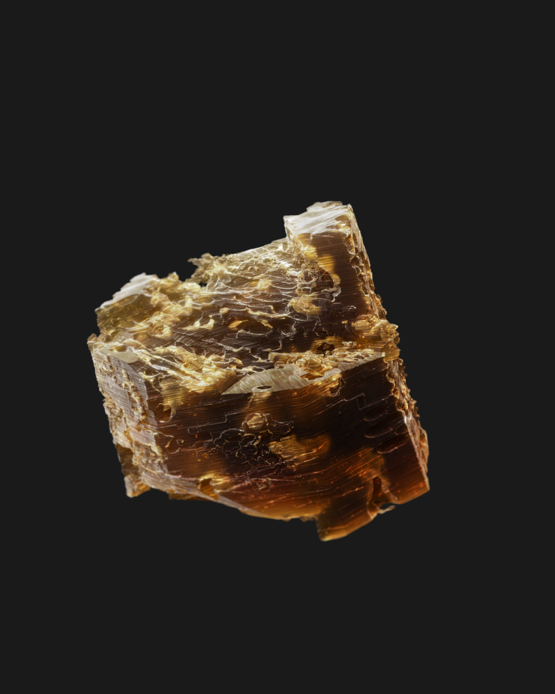 Close-up of flakey golden mica rock. Black background.