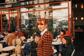 Woman infront of café looking into camera.
