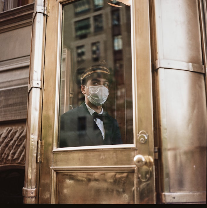 Door man looking out of a window.