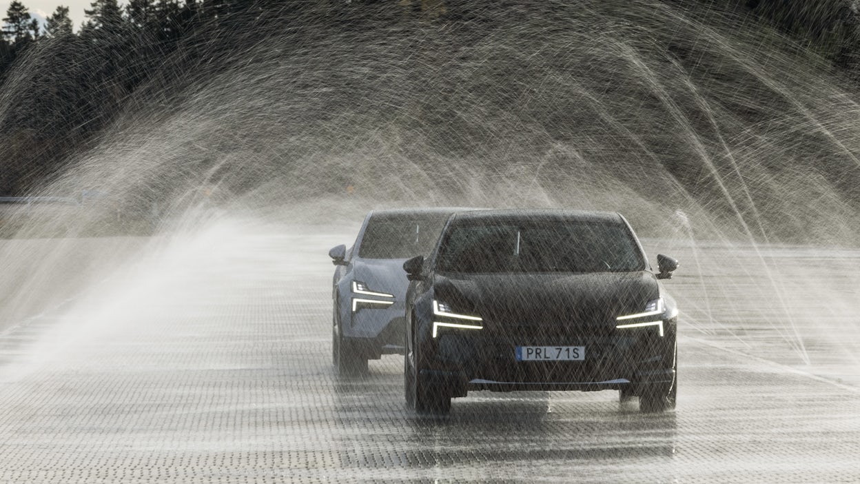 Two polestar 4s drive through water spray