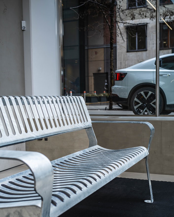 Side profile of Emma's bench, with a Polestar 2 in the background.