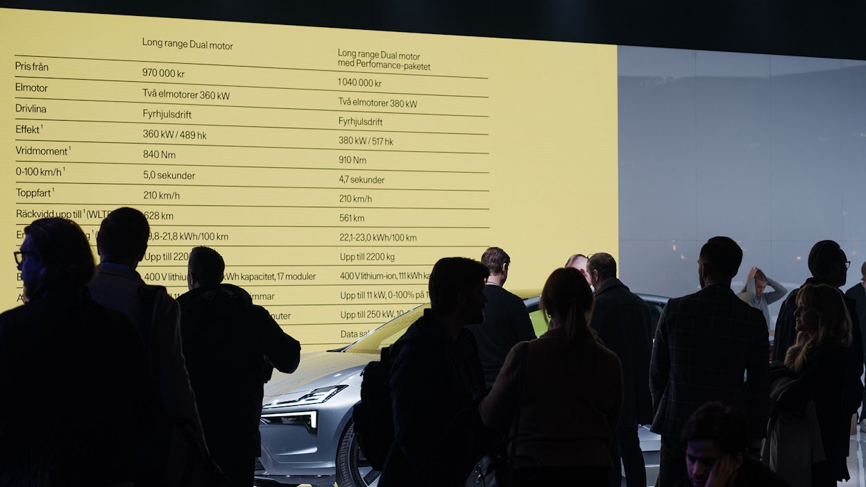 Multiple spectators from The Tech Arena in silhouette, with a screen displaying specifications for a Polestar