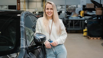 Bethany Martin standing next to a Polestar 5 prototype, smiling at the camera.