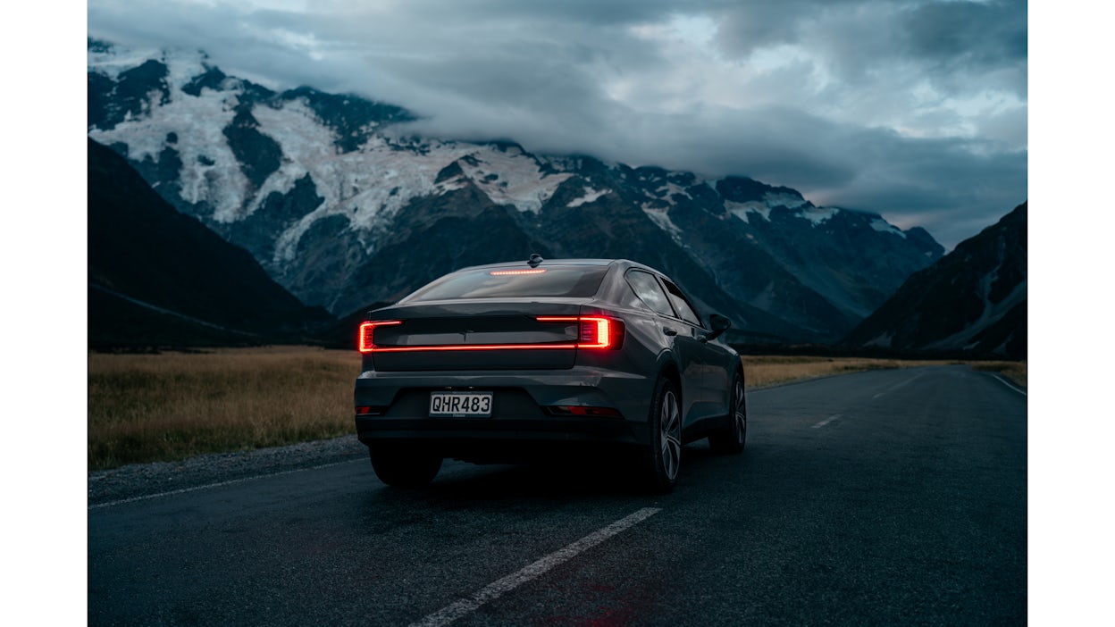 Rear view of Polestar 2 on a road overlooking the mountains of New Zealand