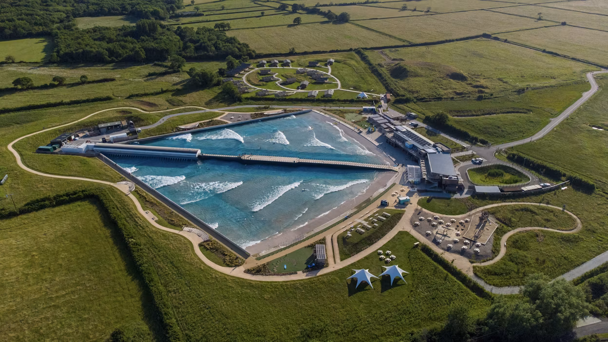 Aerial view of inland surfing lake surrounded by green fields