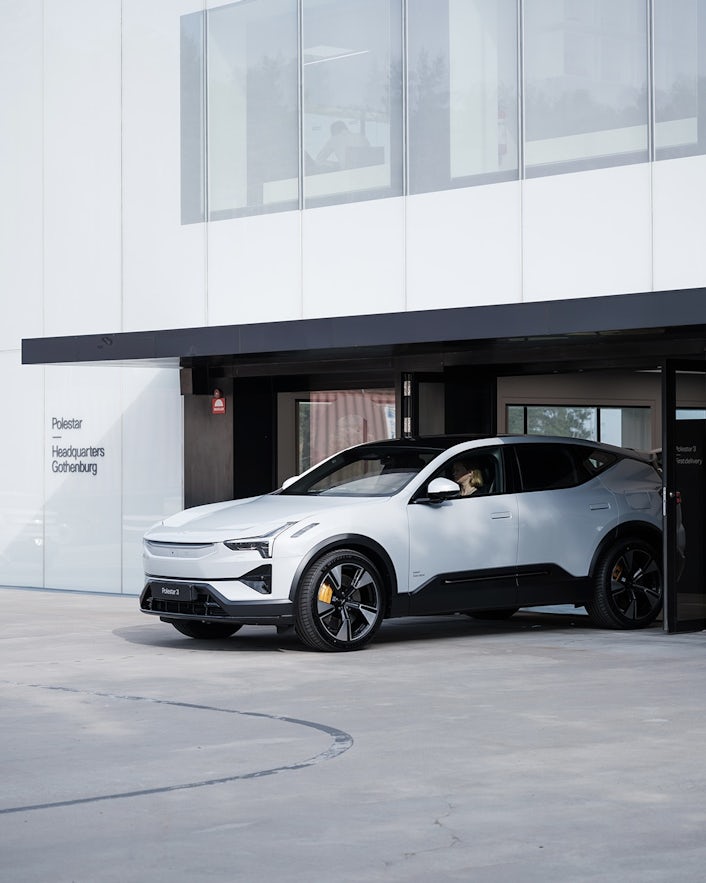 Polestar car parked outside Polestar headquarters in Gothenburg with visible building windows and entrance.