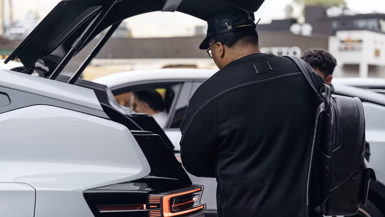 A journalist packing his gear into the trunk of a Polestar 3.