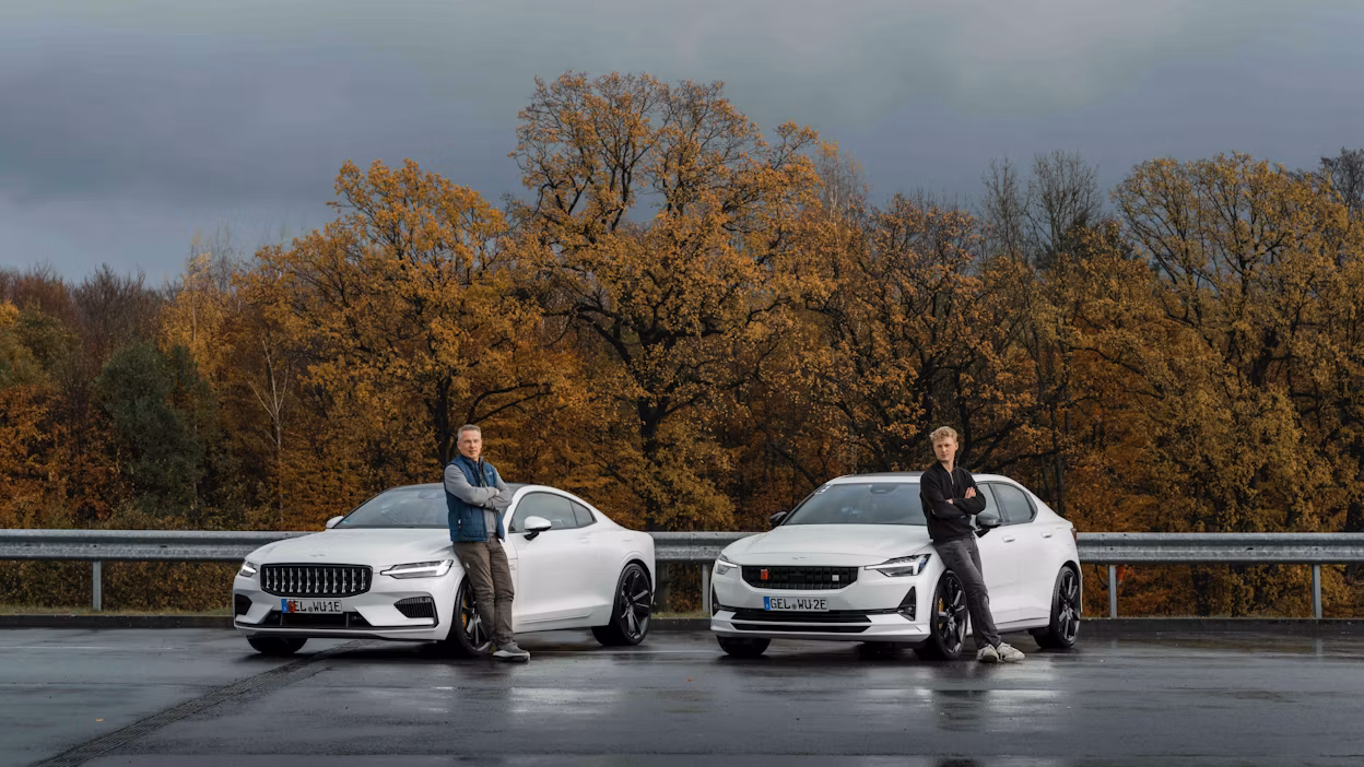 Two people standing in front of a Polestar 1 and 2