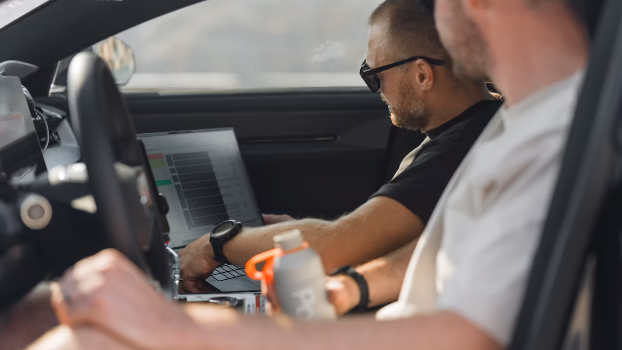 Engineers watching car data on laptop screen in Polestar 5