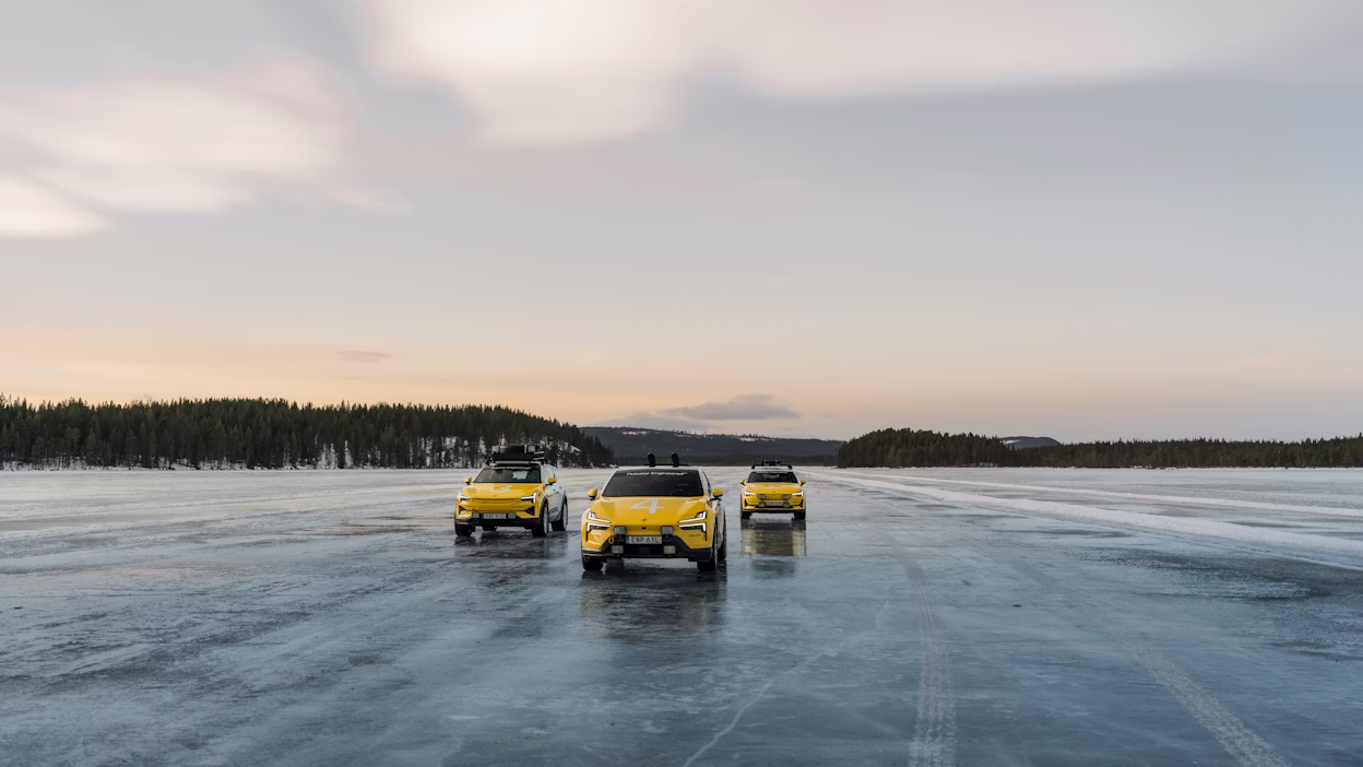 Three white and yellow cars parked on a frozen lake