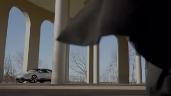 Man walking towards Polestar 4 under arches