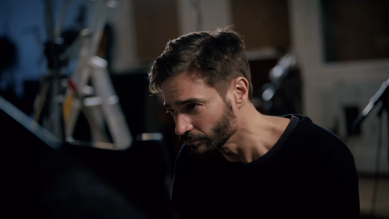 Face of man sitting playing a piano