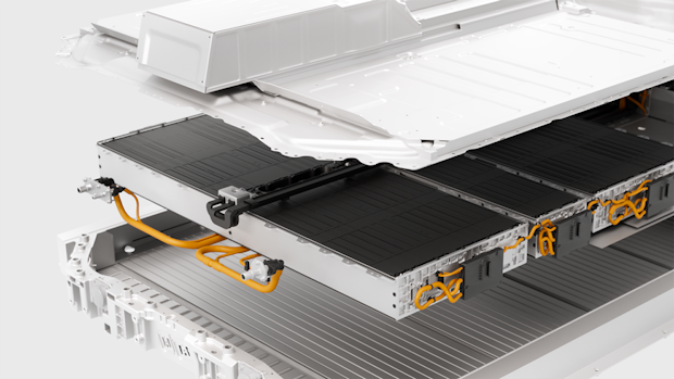 Electric vehicle battery pack with orange cables and layered components, partially enclosed in a white casing.