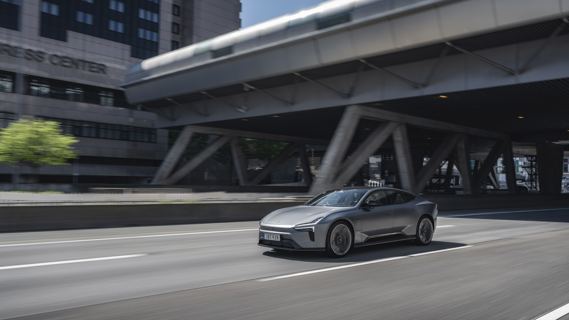 Polestar 5 driving on a city road under an overpass