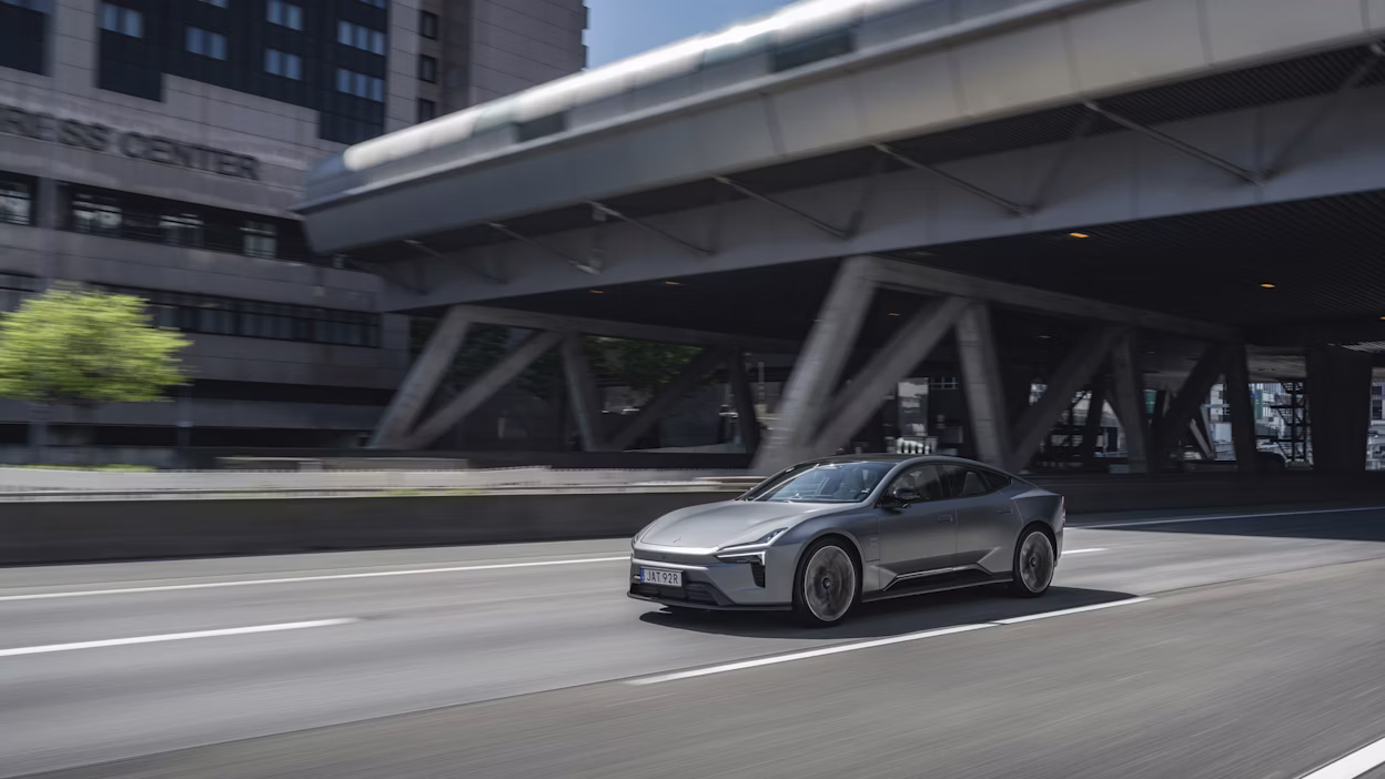 Polestar 5 driving on a city road under an overpass