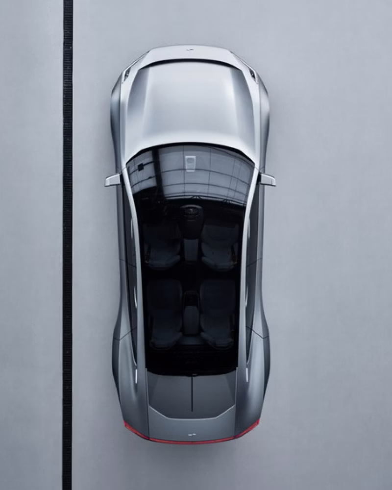 Top view of Polestar car with glass roof and interior seats visible, parked on a gray surface beside a black line.