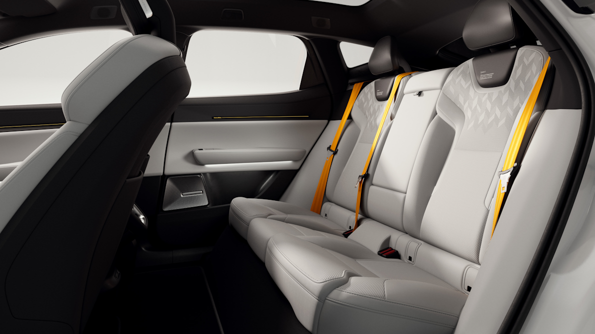Interior view of Polestar 3’s rear seats with Swedish gold seat belts and passenger door.