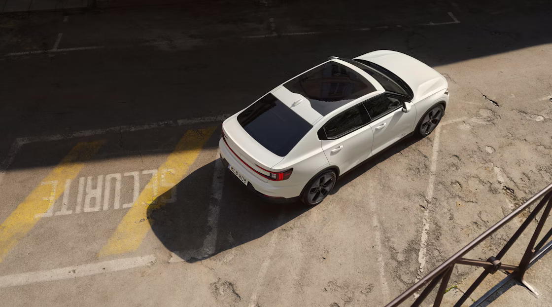 Polestar 2 standing on a parking lot with foreign lettering and worn out markings.