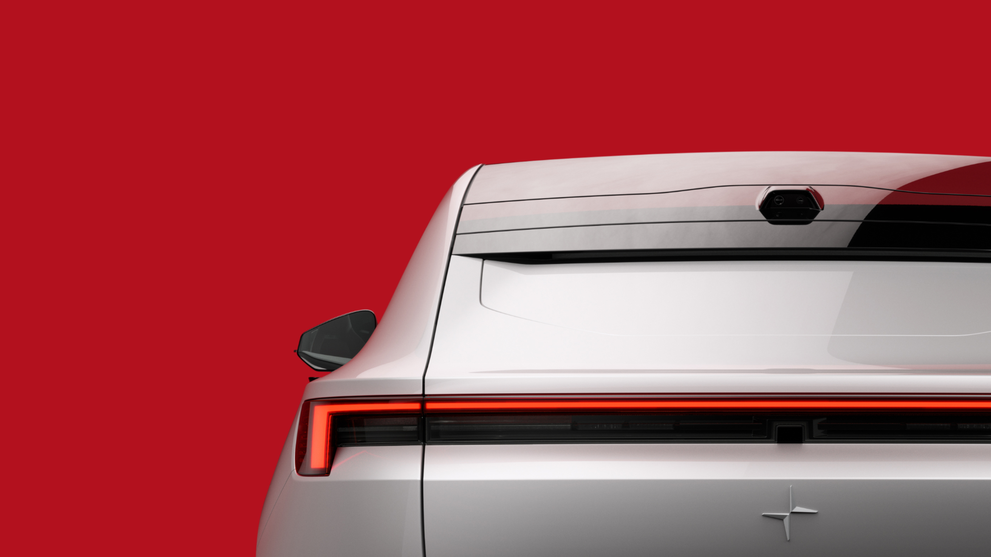 Upper left corner of Polestar 4 in silver grey colour against a red background.