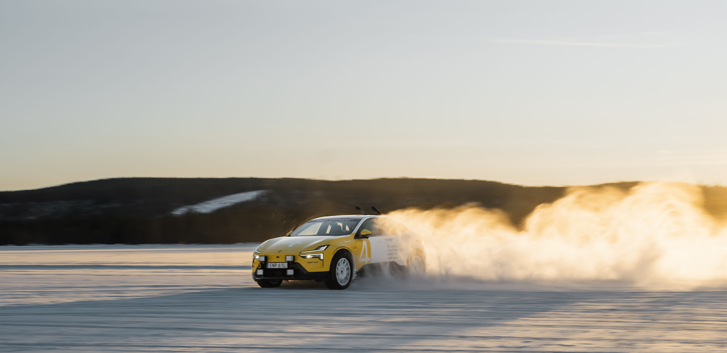 Polestar 4 in yellow and white colour drifting on icy ground outdoors and leaving a dust trail.