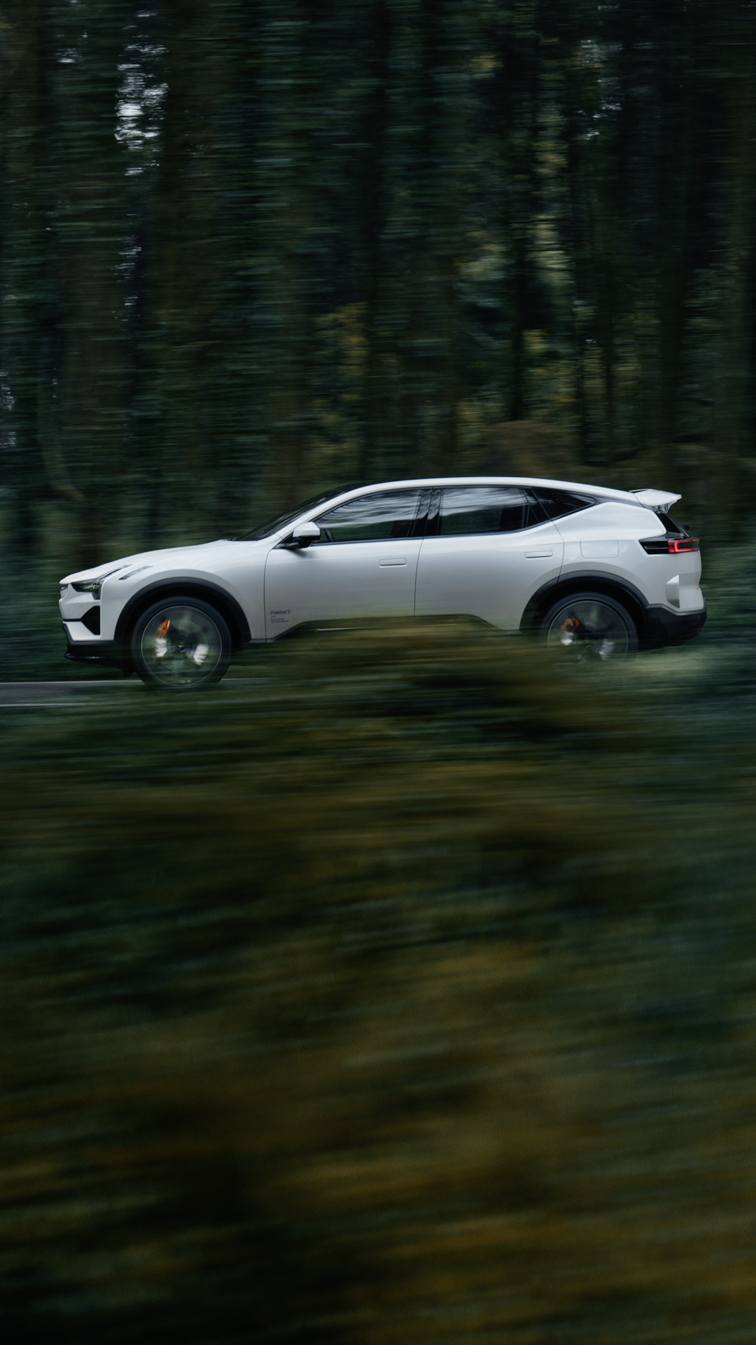 Multiple angles of Polestar 3 in Snow colour driving along the coast and hills.