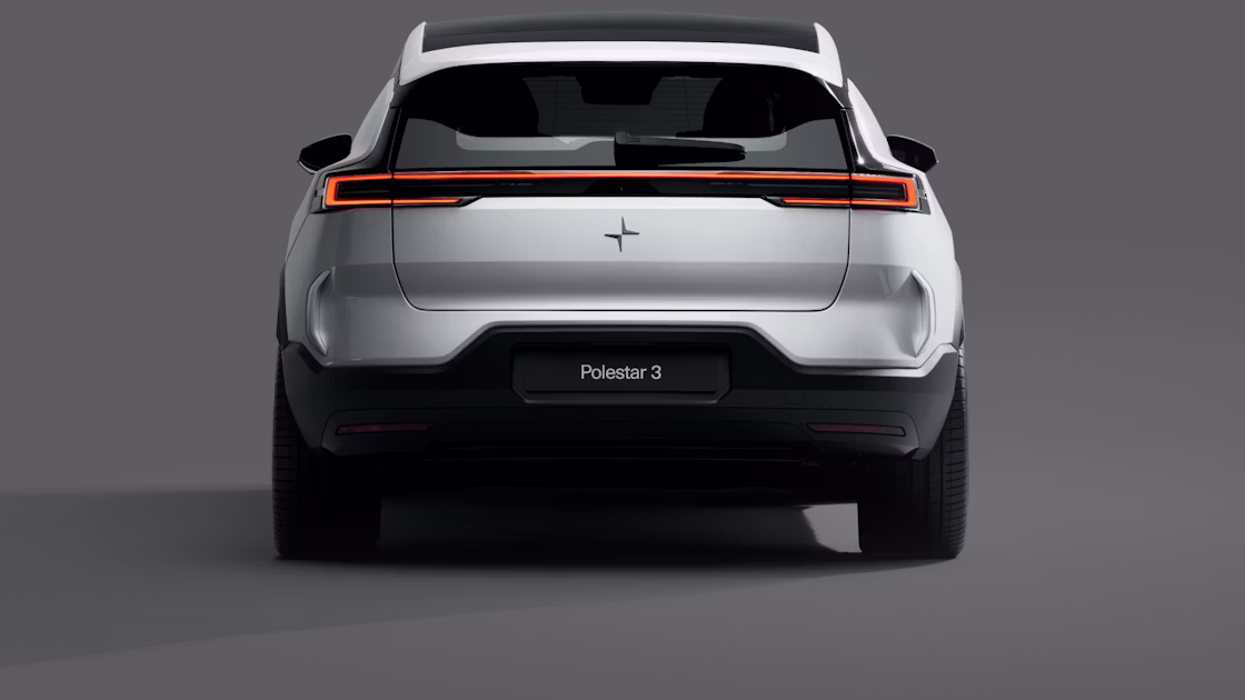 A rear view of a white Polestar 3 standing against a grey background.
