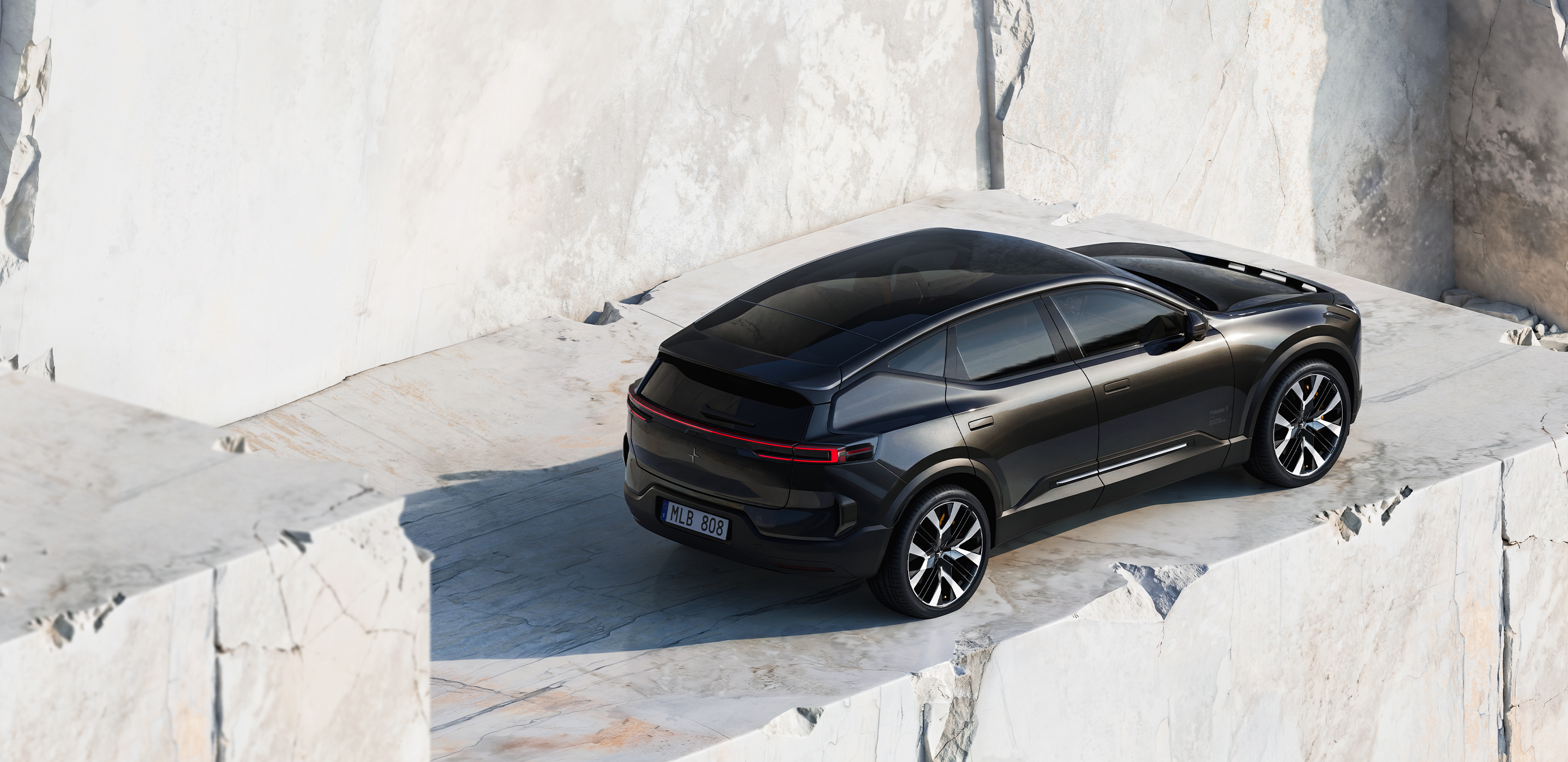 A black Polestar 3 parked on a stone ledge