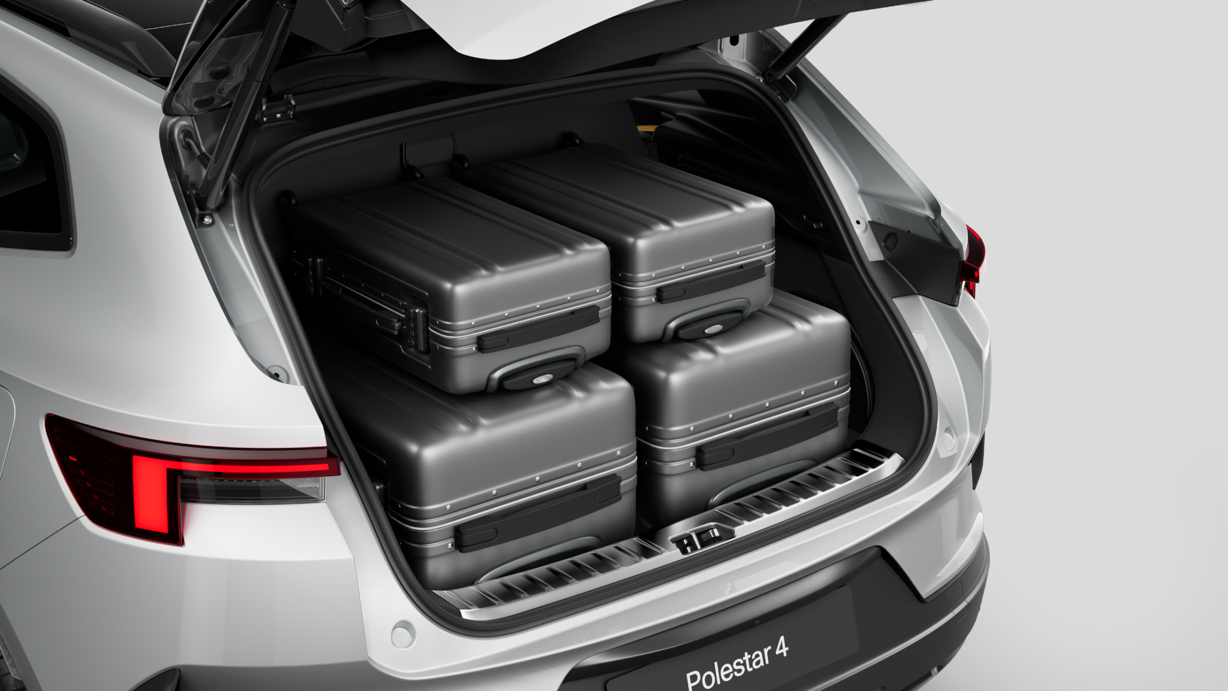 Polestar 4 SUV’s rear luggage compartment with two large suitcases and carry-on sized suitcases.